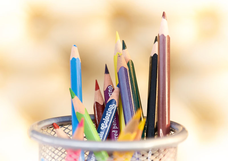 Des crayons de couleur dans un pot, baignés de lumière chaude